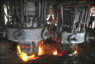 An employee works inside a steel factory.