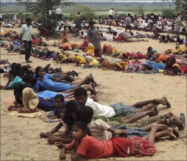 Villagers and their children lie at the proposed site of a $12-billion steel plant by South Korea's Posco during a protest in Orissa on June 11.