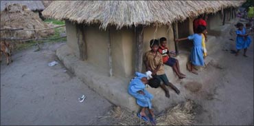Children gather at the entrance of their thatched hut in Gobindpur village.