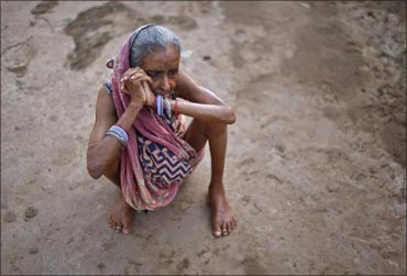 A woman sits on the ground at a transit camp for villagers who have been displaced in Jagatsinghpur.