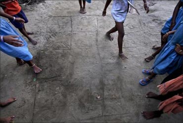 Children play a game of hopscotch on a grid drawn into the dirt in Gobindpur village.