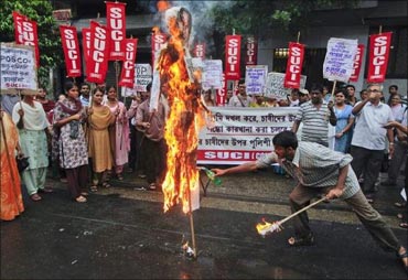 An activist from the Socialist Unity Centre of India burns an effigy of Orissa Chief Minister Naveen Patnaik as others shout slogans during a protest.