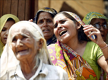 Women weep after police arrested their family members, following clash between farmers and police.