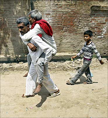 A villager carries an injured man to a hospital after farmers clashed with police.