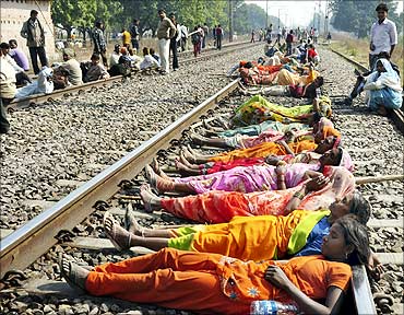Farmers block railway tracks during a protest in Karchana town in UP.