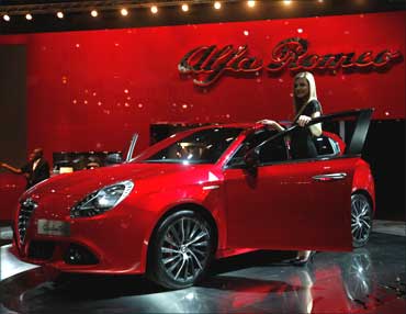 A model poses next to an Alfa Romeo Giulietta.