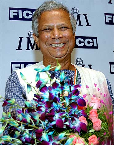 Dr Muhammad Yunus carries a bouquet of flowers presented at Ficci in New Delhi.