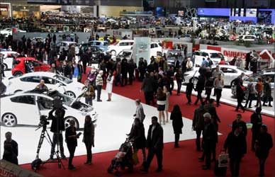 Visitors stroll through the stands on the first day of the 81st Geneva Motor Show at the Palexpo in Geneva.