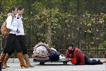 A woman begs on a road in the embassies district of Beijing.