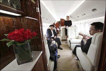 Mainland Chinese visitors sit inside a Dassault Falcon 7X business jet.