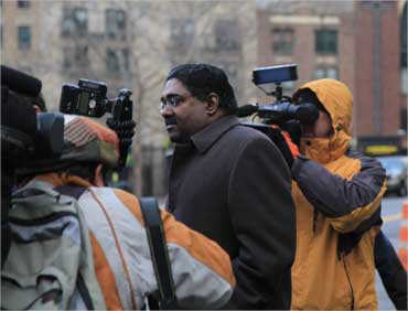 Rajaratnam outside the court house surrounded by media.