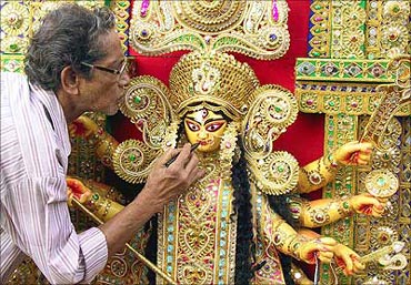 A sculptor gives finishing touches to an idol of Goddess Durga in Kolkata.