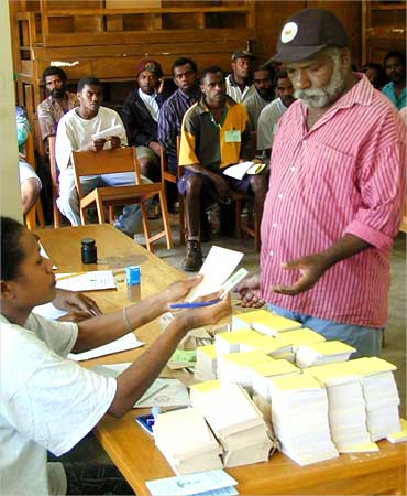 An elderly man receives voting forms during an election in the capital of Vanuatu.
