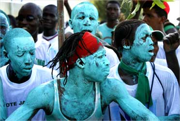 Dancers painted green celebrate on the beach in support of Gambian President.