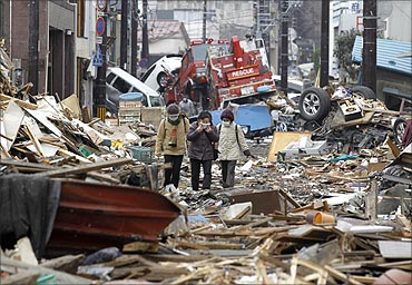 People make their way as they look for their houses among the ruins of the destroyed residential part of Kamaishi