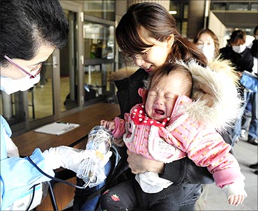 A baby and her mother are scanned for radiation before they enter an evacuation centre in Fukushima Prefecture.