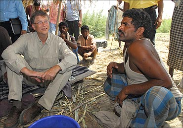 Bill Gates (L) interacts with a villager in Aulali village, in Bihar.
