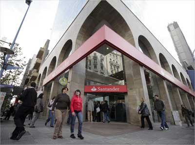Residents walk in front of a Santander bank branch in downtown Montevideo, Uruguay.