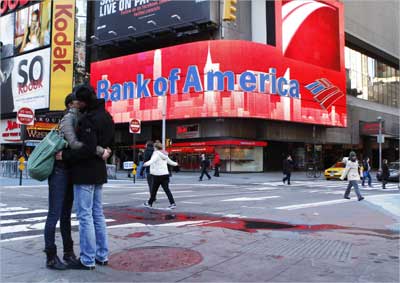 A couple embraces in front of a Bank of America sign on a building in Times Square in New York.