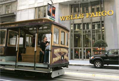 A cable car passes a Wells Fargo bank building along California Street in San Francisco.