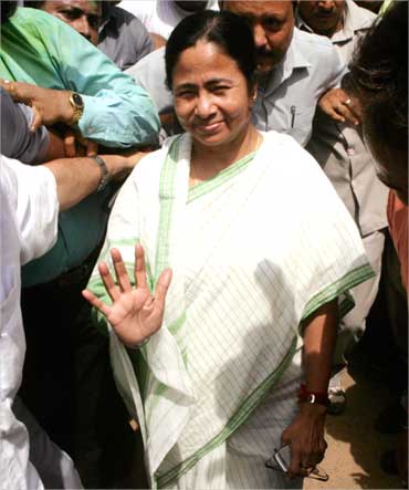 Mamata Banerjee waves to supporters outside her residence in Kolkata.