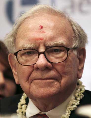 Warren Buffett, wearing a traditional 'tika' pauses during a news conference in Bengaluru.