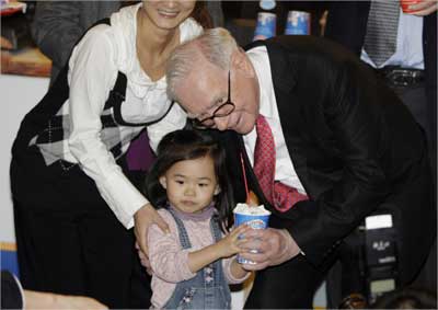 Buffett gives a cup of DQ ice cream to a Chinese girl during his visit to a new Dairy Queen store in Beijing.
