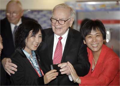 Buffett (C) takes out his wallet to pose for a photo during his visit a new Dairy Queen store in Beijing.
