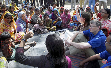 Bill Gates and his wife Melinda interact with slum dwellers during their visit to a slum area in Danapur, Bihar.