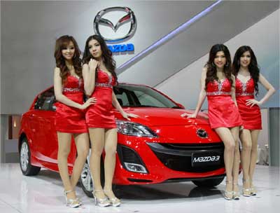 Models pose beside a Mazda 3 during the 32nd Bangkok International Motor Show in Bangkok March 24, 2011.