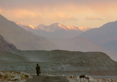 A pedestrian walks through the Khardung La Pass, which leads through the barren mountains of Ladakh.