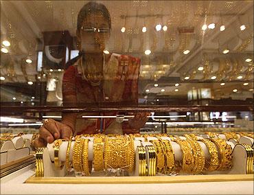 A saleswoman arranges gold jewellery inside a showroom in Kolkata.