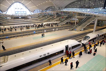 Travellers board a high-speed train which heads to Guangzhou in Wuhan.