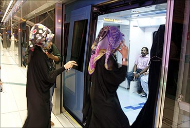 Women walk into a train after the official opening of the Gulf Emirate's first metro network.
