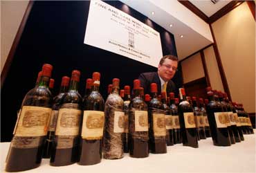 Acker Merrall's president John Kapon poses with a lot of 70 Chateau Lafite Rothschild bottle.