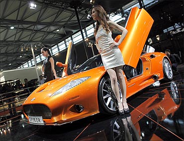 Models pose next to a Spyker C8 Aileron during the Shanghai Auto Show.