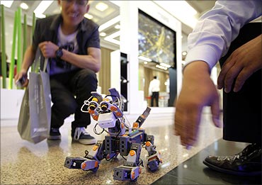 A man looks at a demonstration of a prototype of a dog robot during the 2011 IEEE conference.