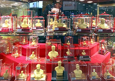 A vendor places a gold statue featuring late Chinese leader Mao Zedong at a gold store in Xiangtan.