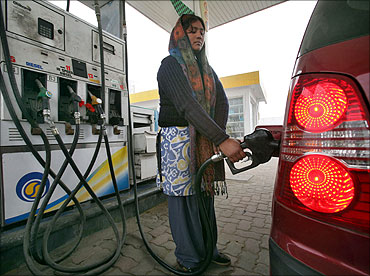 An employee fills a vehicle with petrol at a fuel station in Jammu.