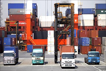 Containers are unloaded from a truck for export at Yokohama port in Yokohama.