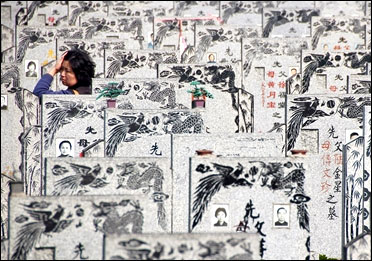 A Chinese woman walks among tombstones at Songhe graveyard in Shanghai.