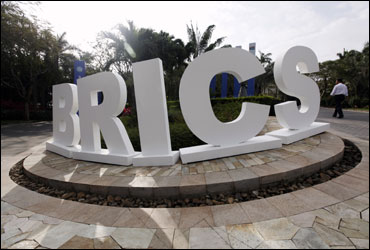 A man walks past a signage decoration for the BRICS summit.