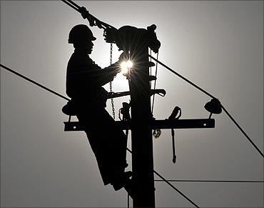 worker repairs an utility pole on the outskirts of Yingtan.