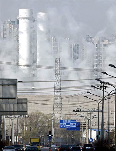 Chimneys and buildings are seen through thick steam at Taiyanggong Gas-fired Thermal Power Station.