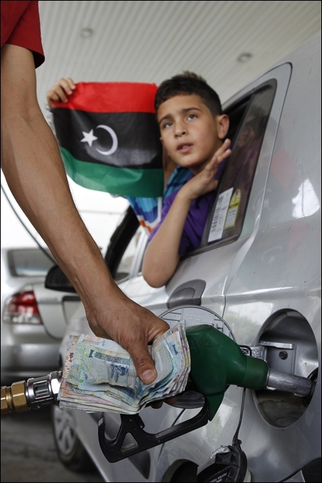 A man fills up the tank of a car at a petrol station in Tripoli.