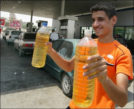 A Bahraini youth sells bottles of petrol to queuing motorists in Manama.