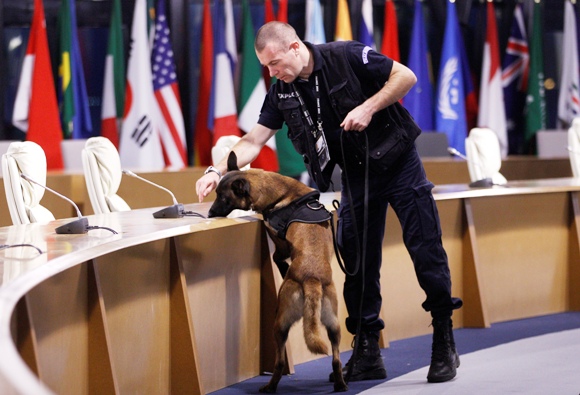 A French police officer with a sniffer dog checks the plenary room at the venue of the G20 summit.