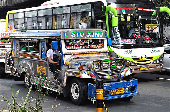 A jeepney and a bus, common forms of public transport in the Philippines.