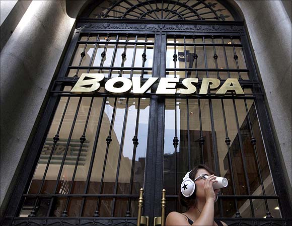 A woman drinks coffee in front of the stock exchange in Sao Paulo.