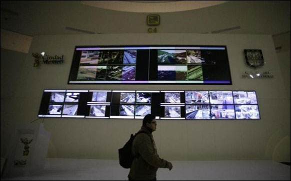 A man walks past screens during the opening of the new C4I4 Emergency Operations Centre in Mexico City.